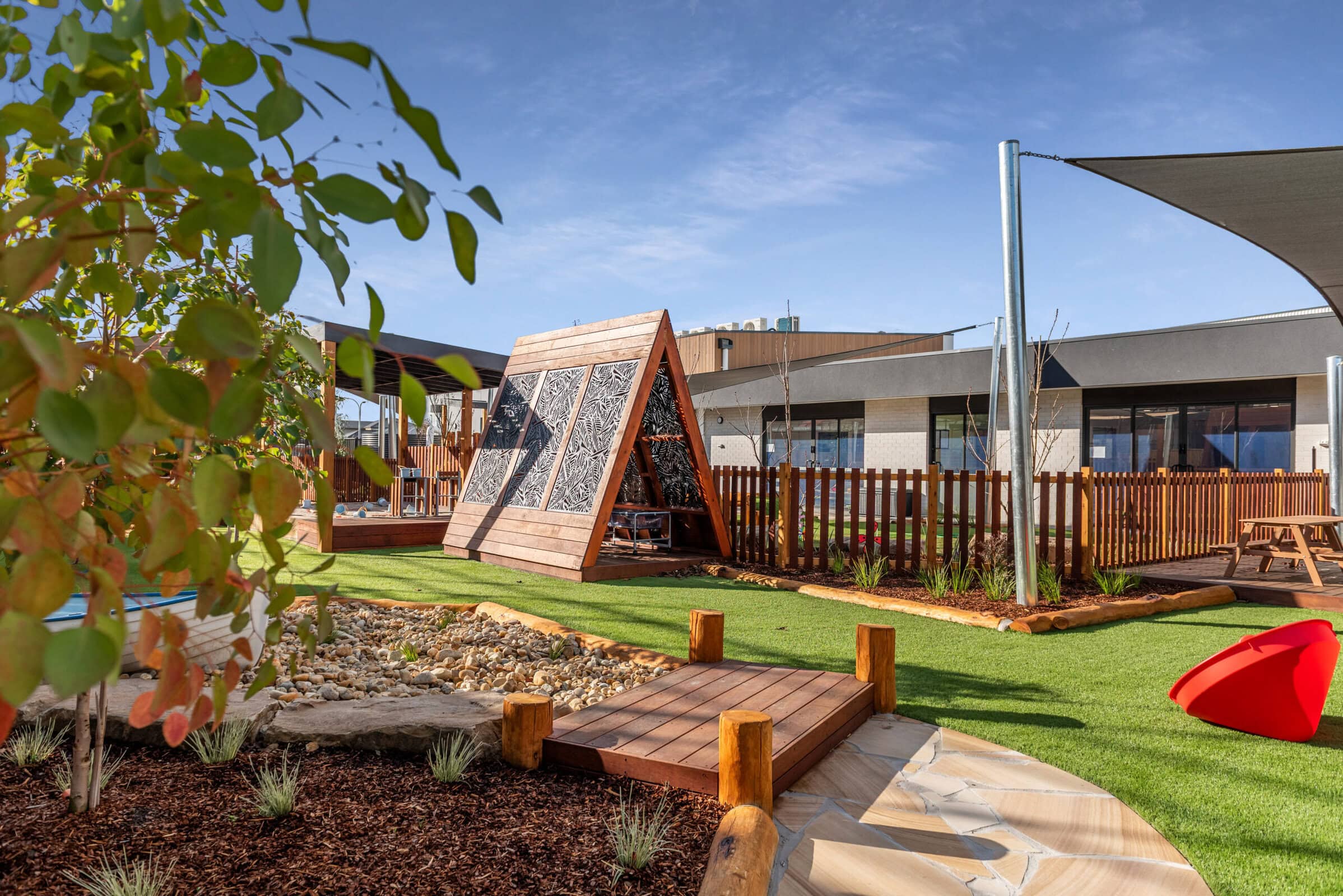 Childcare centre outdoor play area with teepee and natural play equipment