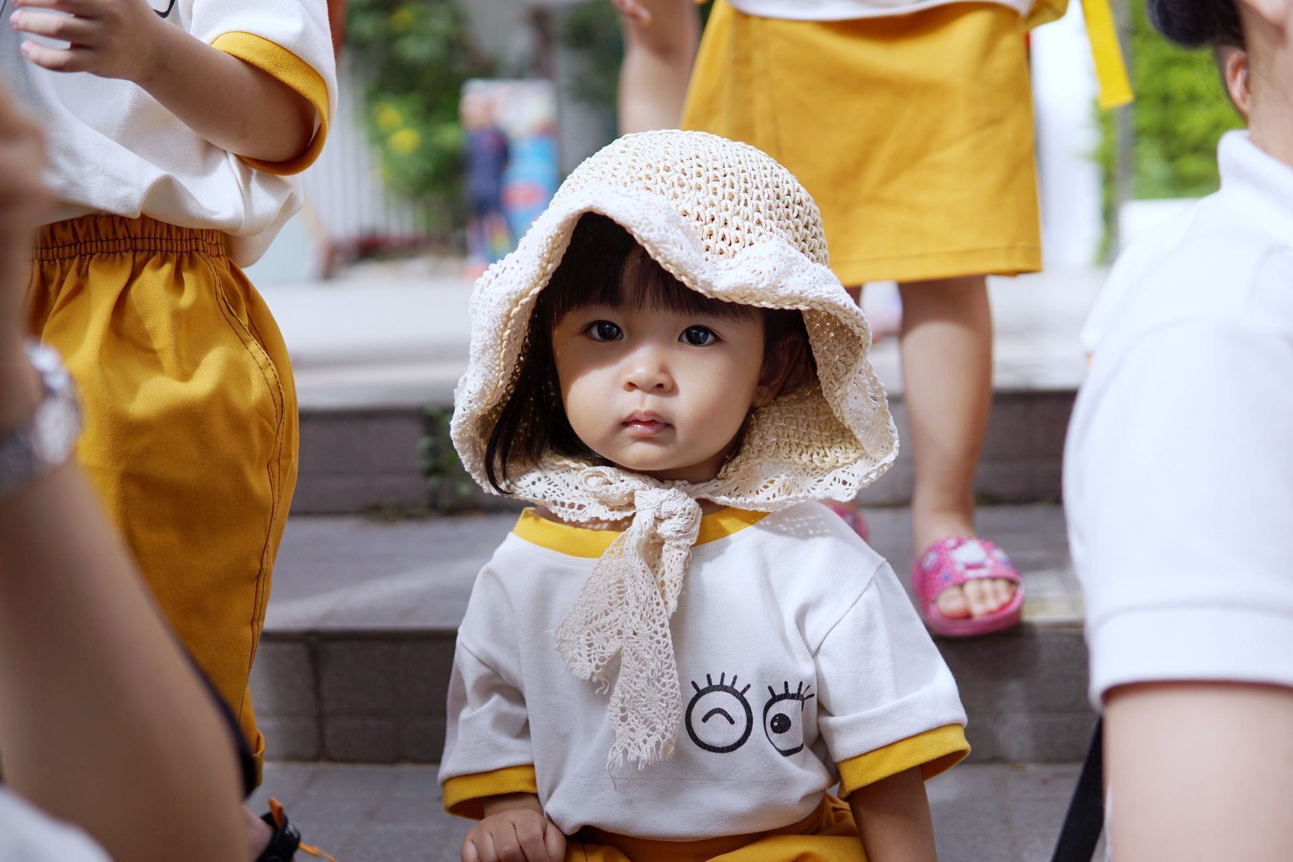 Adorable young girl in school uniform and knitted hat outdoors.